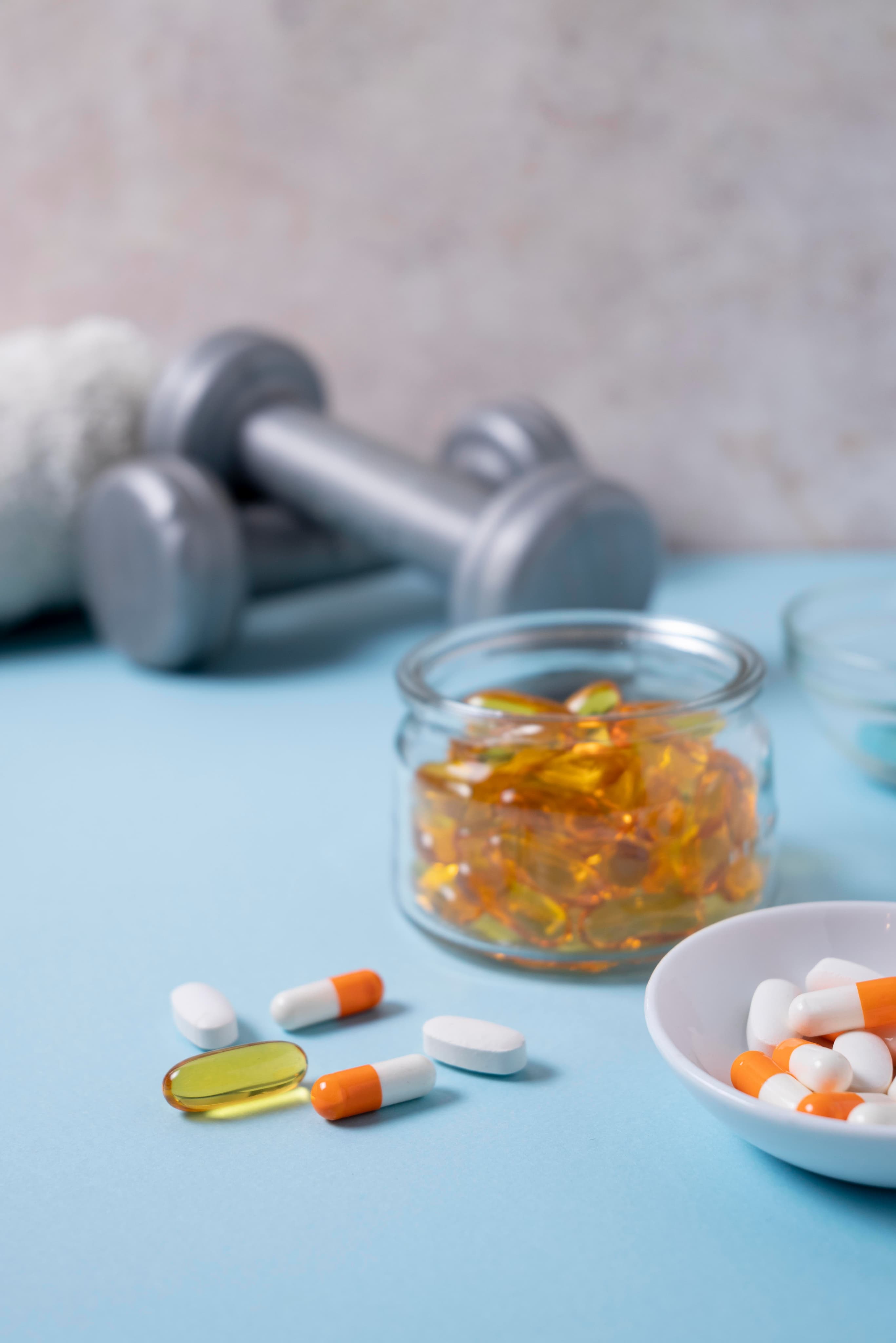 Sports medicine pills and dumbbells